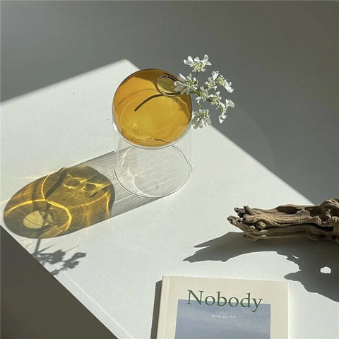 Orange vase with flowers reflecting in the sun