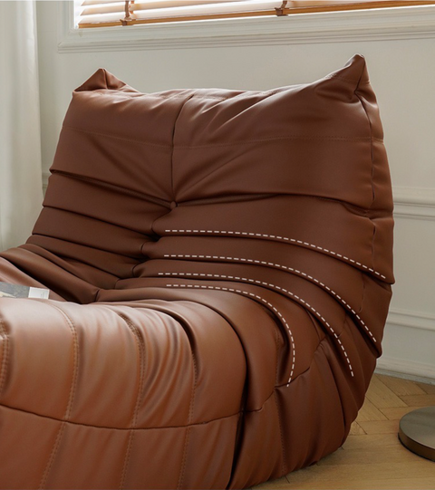 Close up of leather-look slouch couch chair.